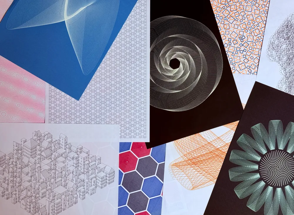 A spread of finished pen-plotter drawings made with GD Studio, fanned out across a desk